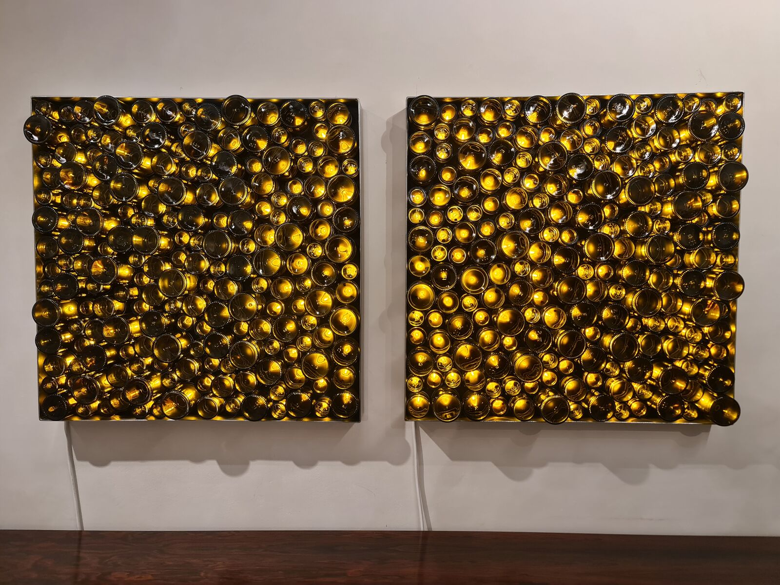 Two wall panels of backlit amber glass jars