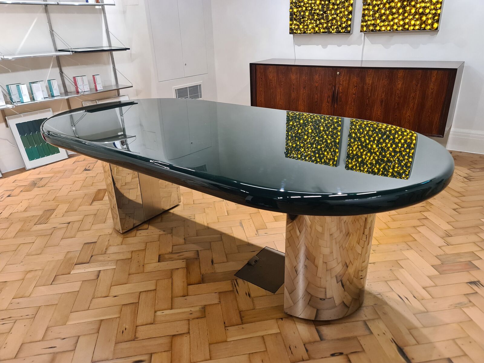 Deep green gloss table with rounded ends on mirror-polished stainless legs