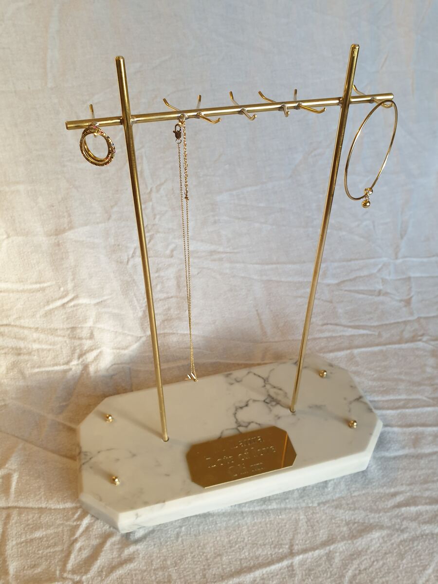 Brass necklace stand on a marble base